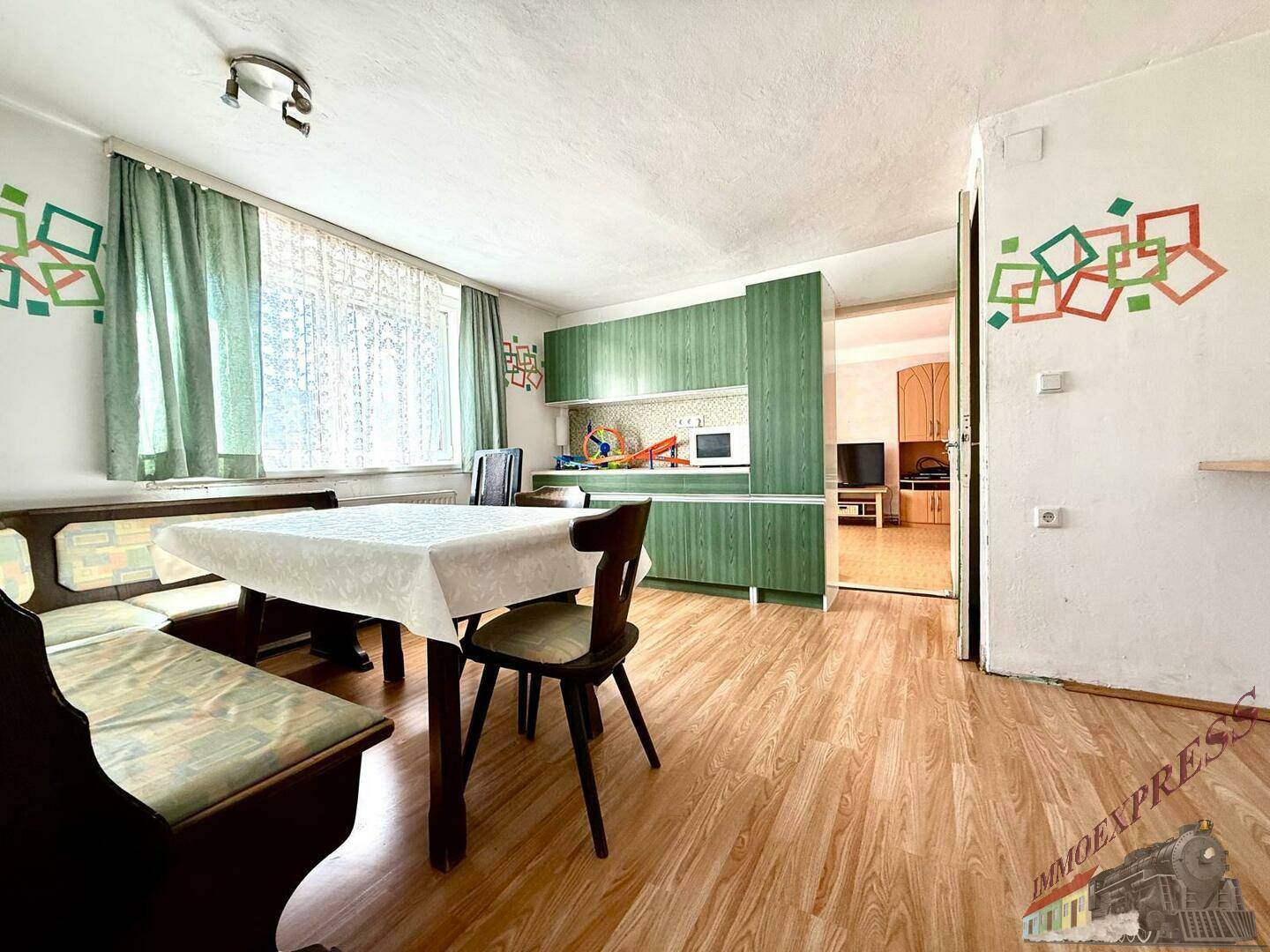 Grüne Einbauküche mit Essbereich und Fenster, in einem funktionalen Stil gestaltet.