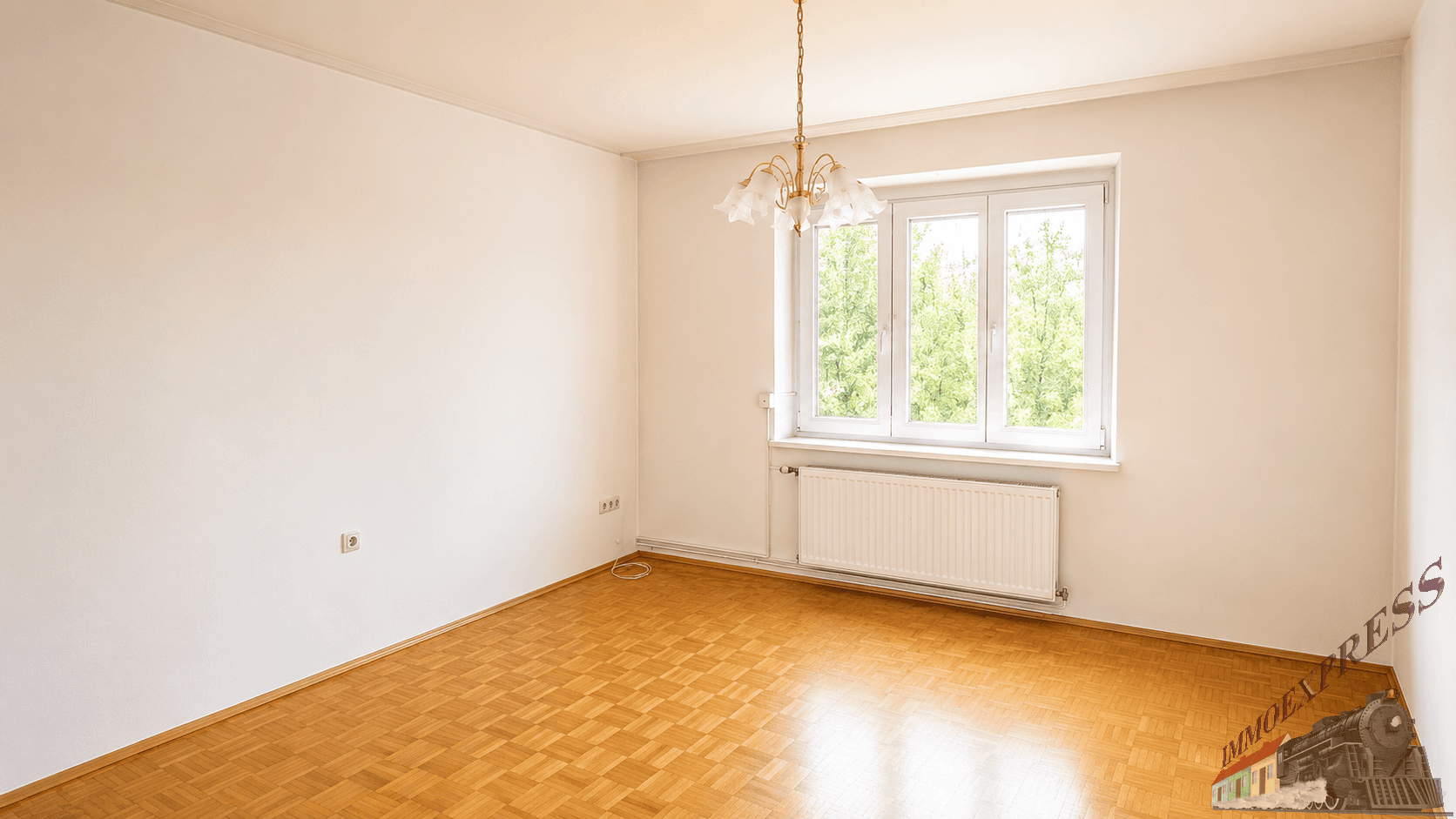 Heller Raum mit Parkettboden und großem Fenster, ideal als Wohn- oder Schlafzimmer.