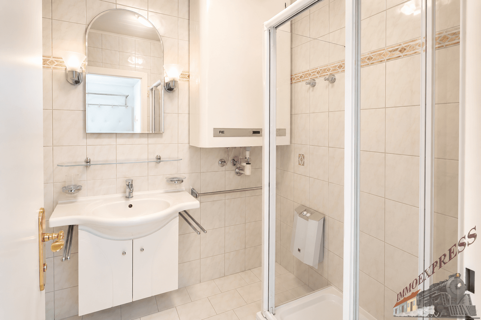 Helles Badezimmer mit Fliesen, Waschbecken, Spiegel und einer Duschkabine.