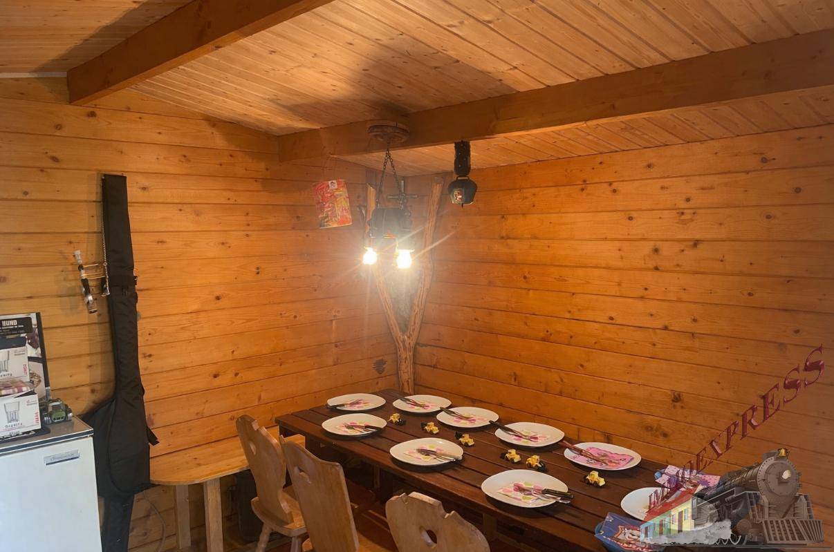 Rustikaler Essbereich mit Holztäfelung, Holzbalken und traditionellen Holzmöbeln.