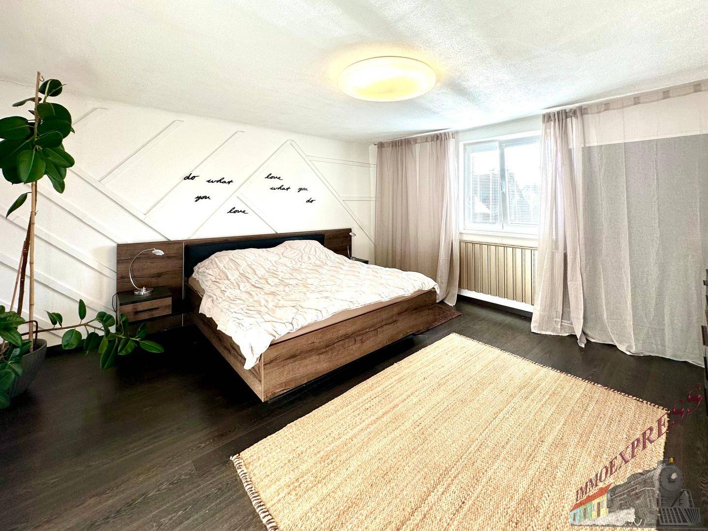 Modernes Schlafzimmer mit Holzbett, dunklem Boden und dekorativer Wandgestaltung.