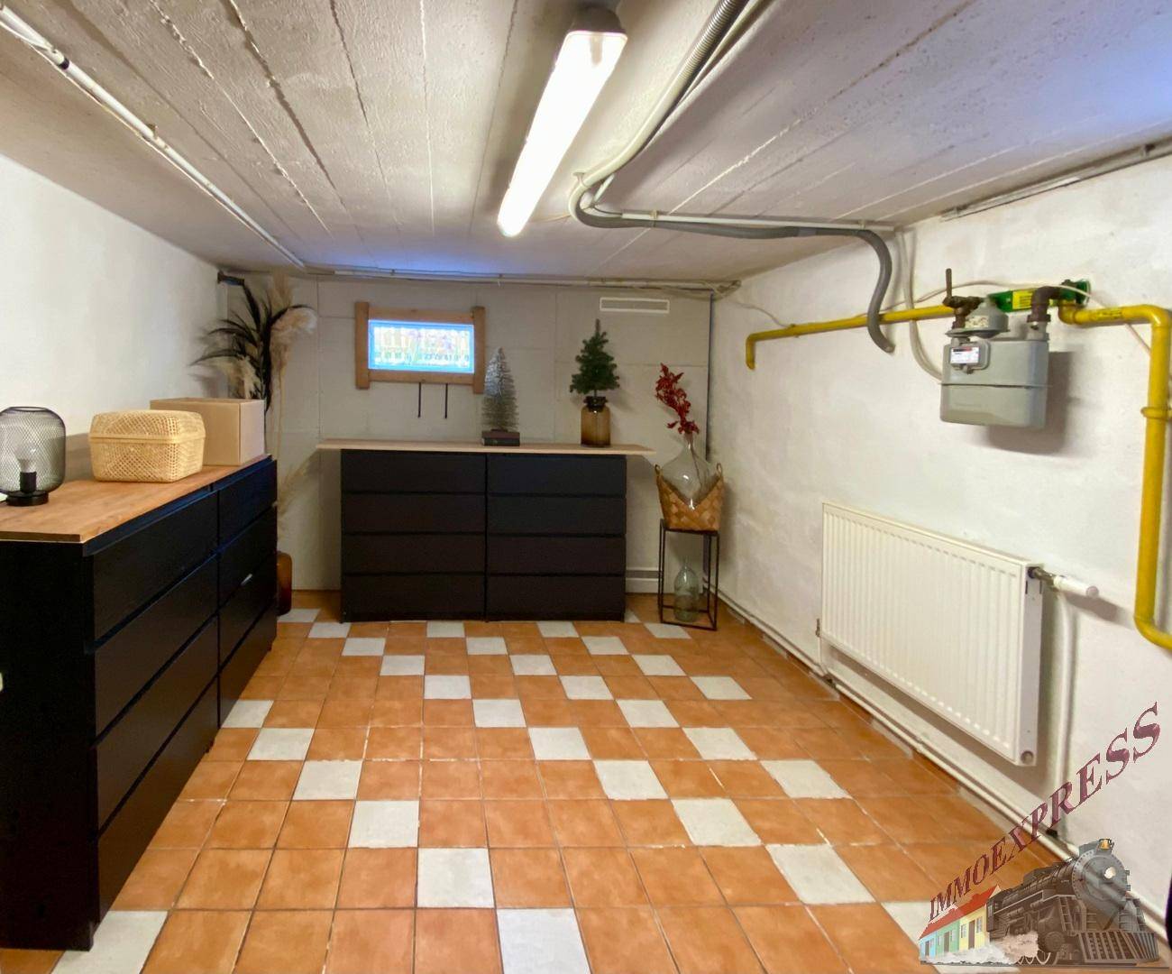 Geräumiger Kellerraum mit gefliestem Boden und Stauraum, ideal für Hobbys oder Lagerung.