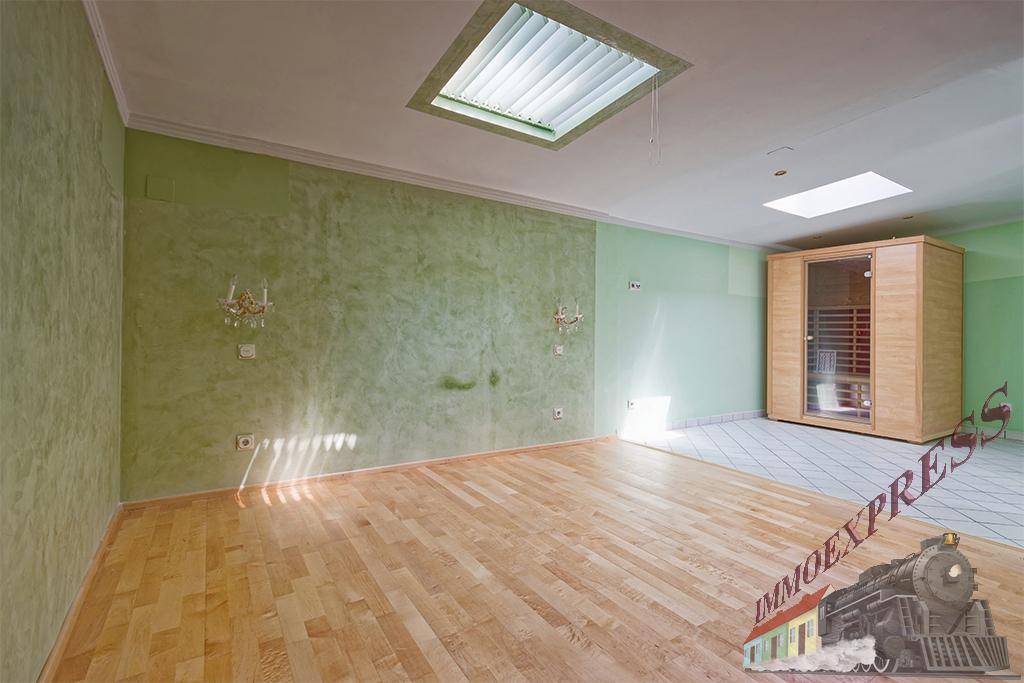 Geräumiger Raum mit Sauna, Parkettboden und grünen Wänden, ideal für Entspannung.