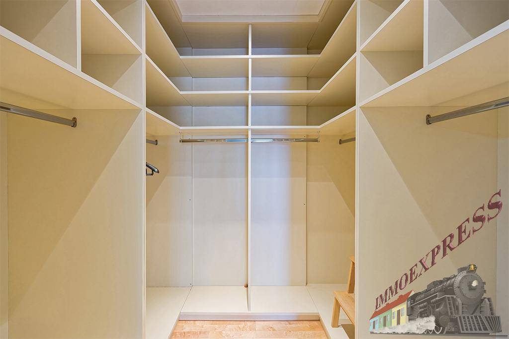 Begehbarer Kleiderschrank mit vielen Regalen und Stangen für optimale Organisation.