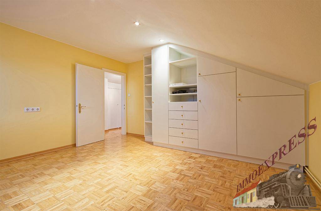 Dachzimmer mit Parkettboden und praktischen Einbauschränken unter der Dachschräge.