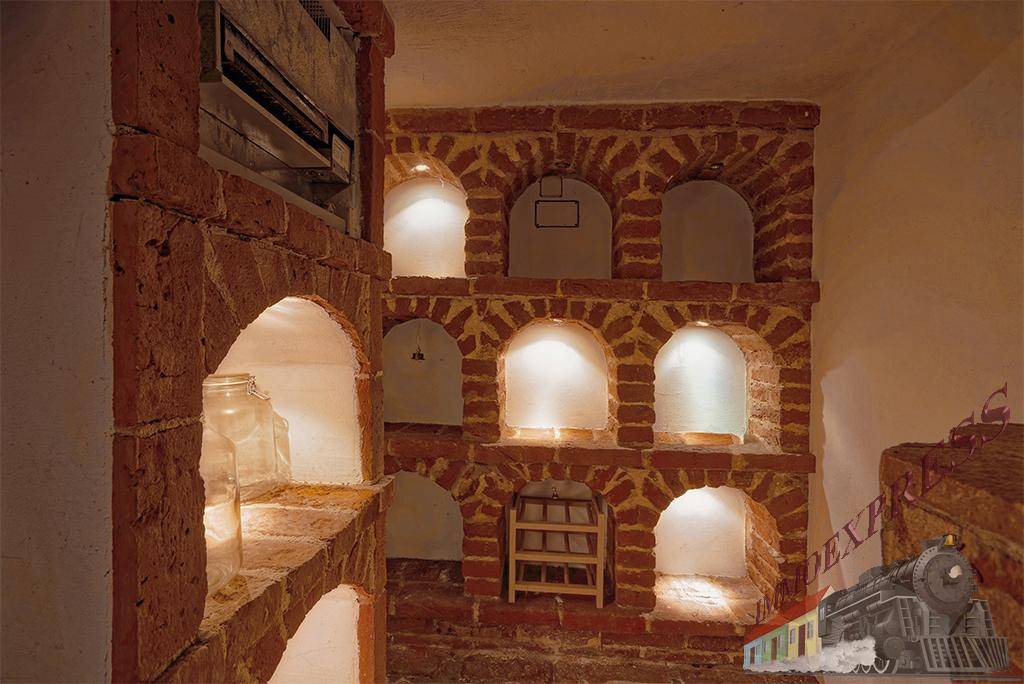 Rustikaler Kellerraum mit Ziegelgewölben und integrierter Beleuchtung, ideal für Weinlagerung.