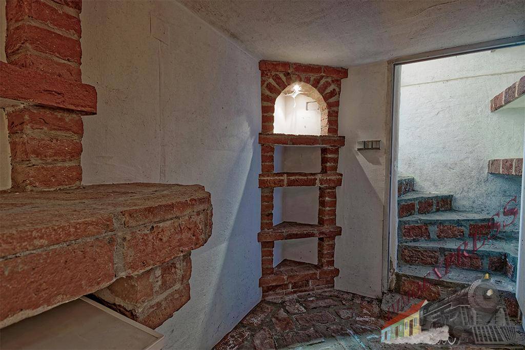 Kellerraum mit Ziegeldetails und Treppenzugang, ideal für zusätzlichen Stauraum und Vorräte.