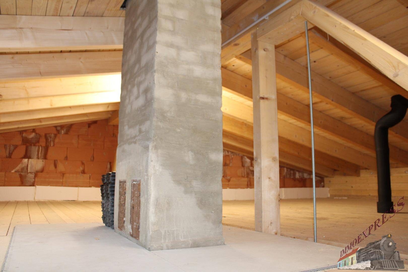 Unausgebauter Dachboden mit sichtbaren Holzbalken und Kaminzug, bietet Ausbaupotenzial.