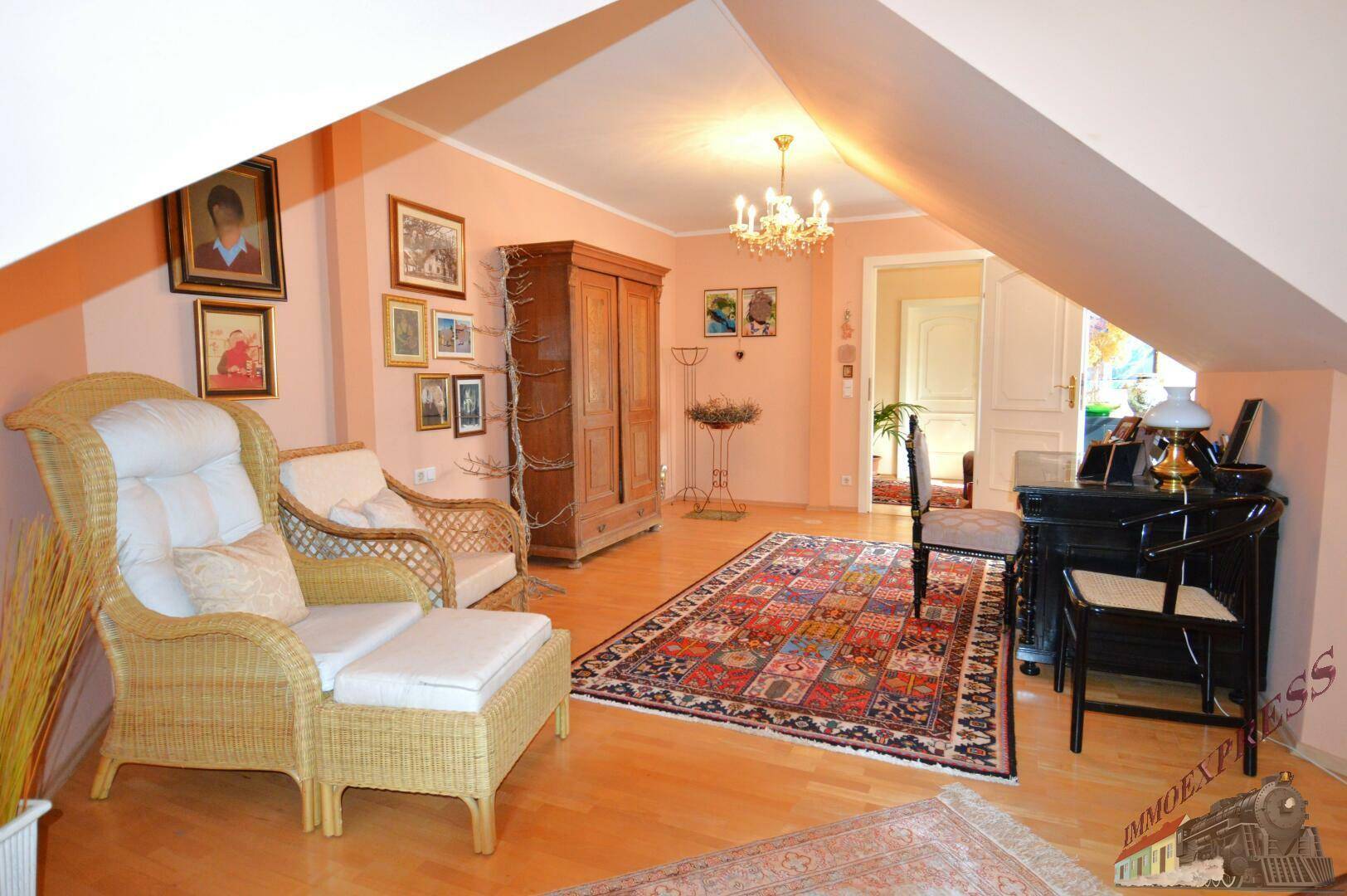 Gemütliches Wohnzimmer im Dachgeschoss mit Holzboden und traditionellen Möbeln.