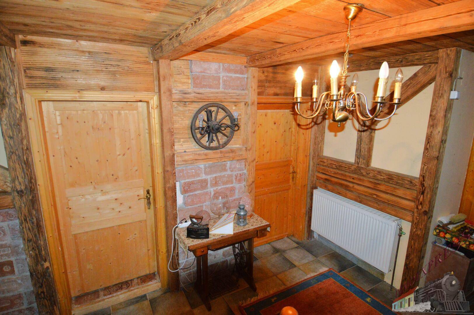 Rustikaler Flur mit Holztüren, Ziegelwänden und traditioneller Beleuchtung.