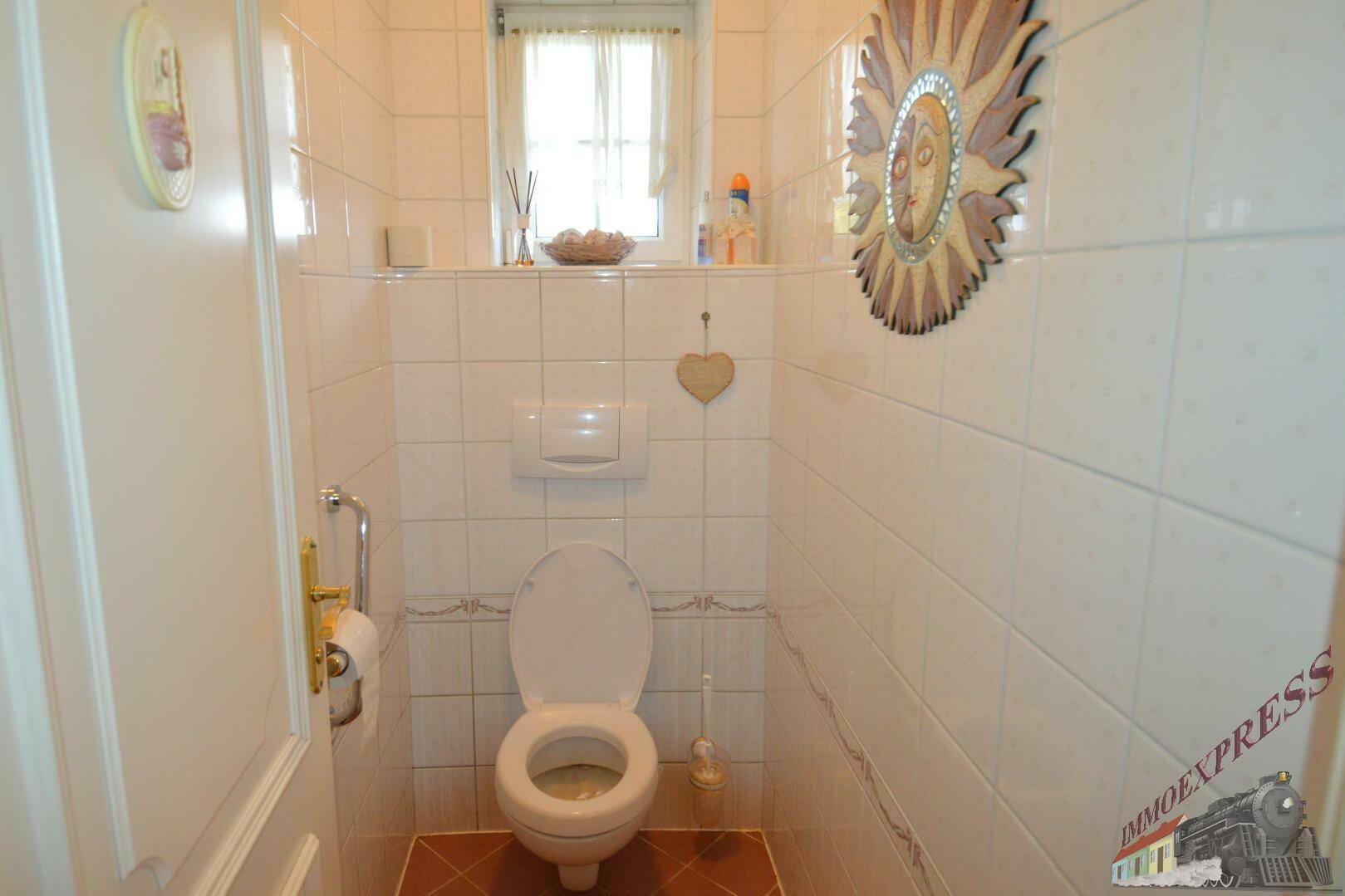 Kleines Gäste-WC mit weißen Fliesen, wandhängender Toilette und Fenster.