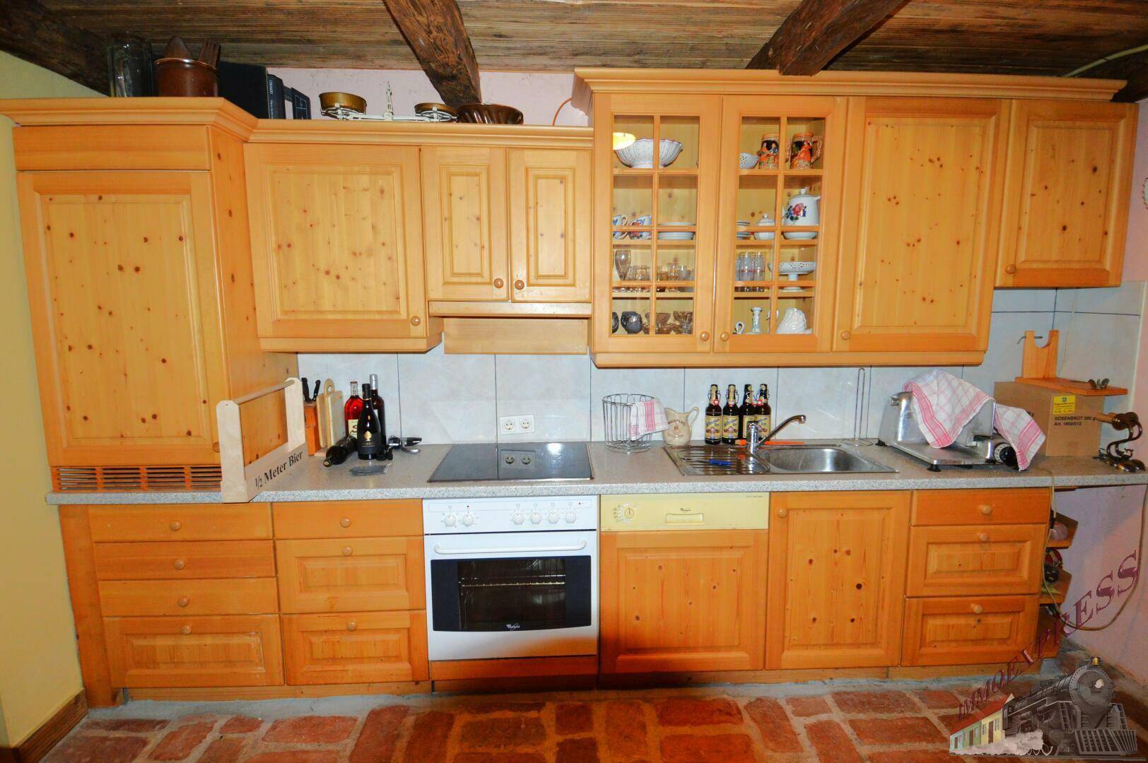 Traditionelle Holzküche mit Einbauschränken, Kochfeld und Backofen.