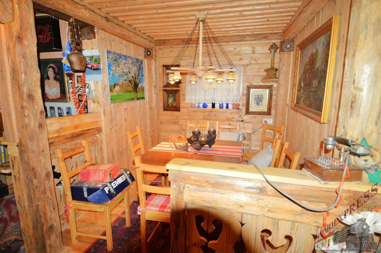 Gemütlicher Essbereich mit Holztäfelung, Holztisch und traditioneller Beleuchtung.