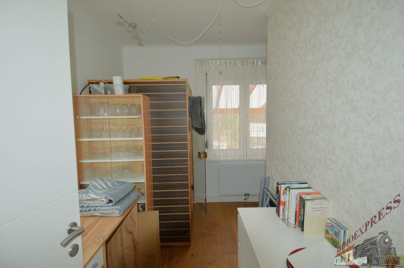 Kleiner Abstellraum mit Regalen und einem Fenster, ideal für zusätzlichen Stauraum.