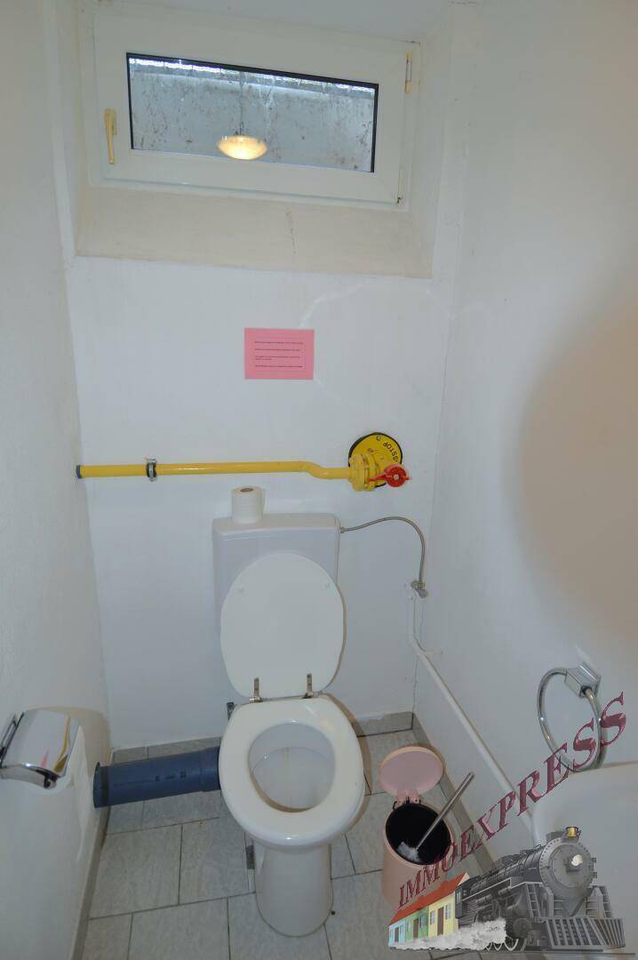 Kleines WC im Keller mit Fenster, Fliesenboden und einfacher Ausstattung.