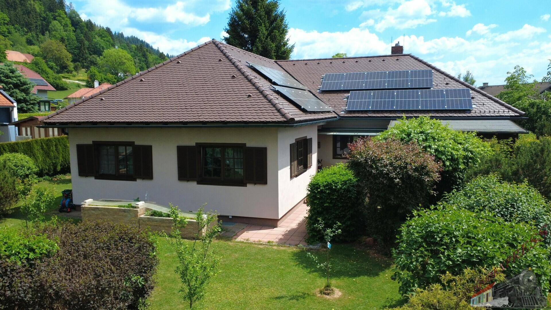 Vorderansicht des Hauses mit geschlossenen Fensterläden und einem gepflegten Vorgarten.