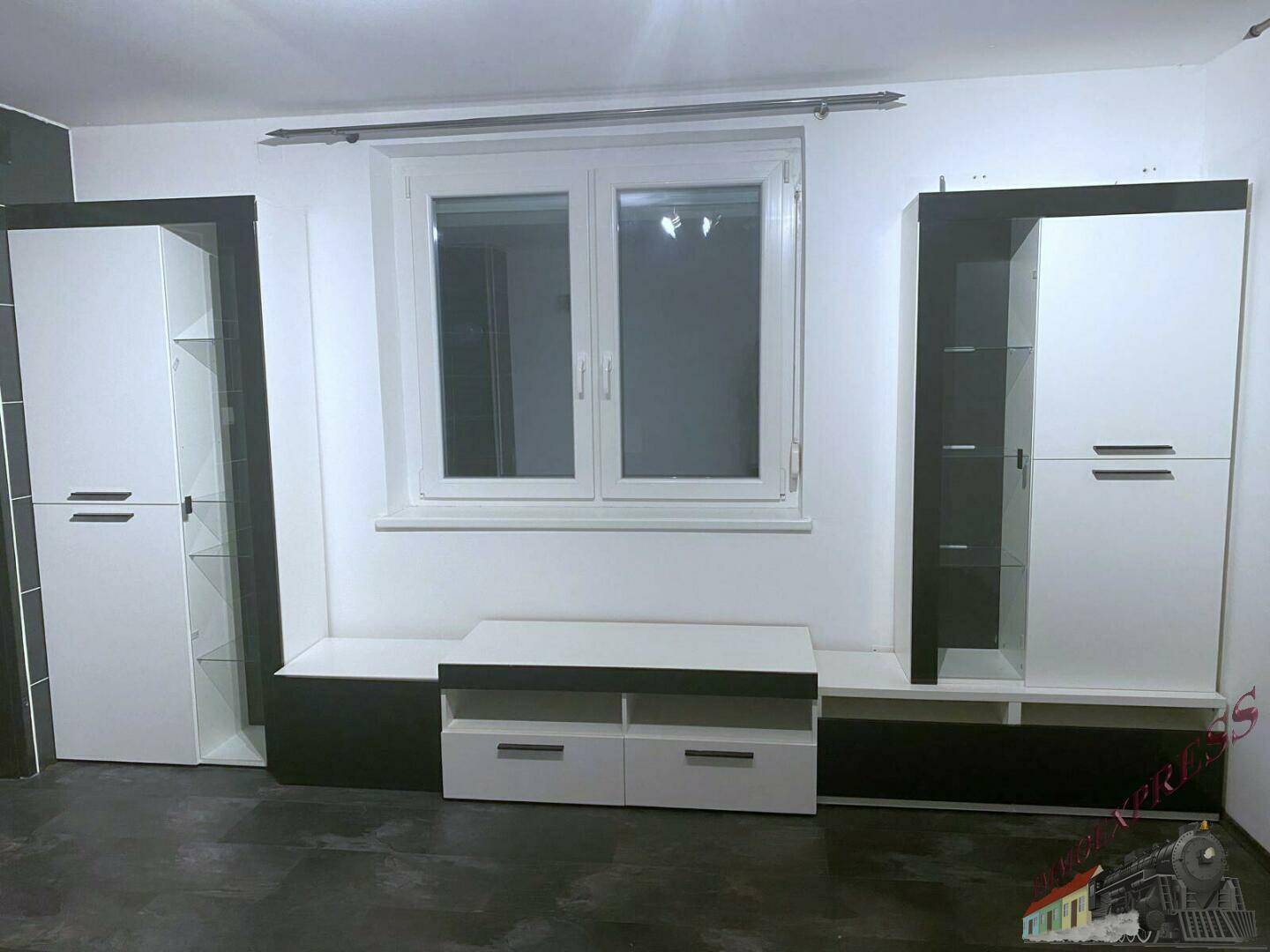 Wohnzimmer mit modernen schwarz-weißen Möbeln, Fenster und dunklem Boden.