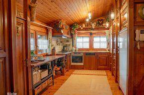 Traditionelle Holzküche mit Einbauschränken, Holzdecken und integrierten Küchengeräten.