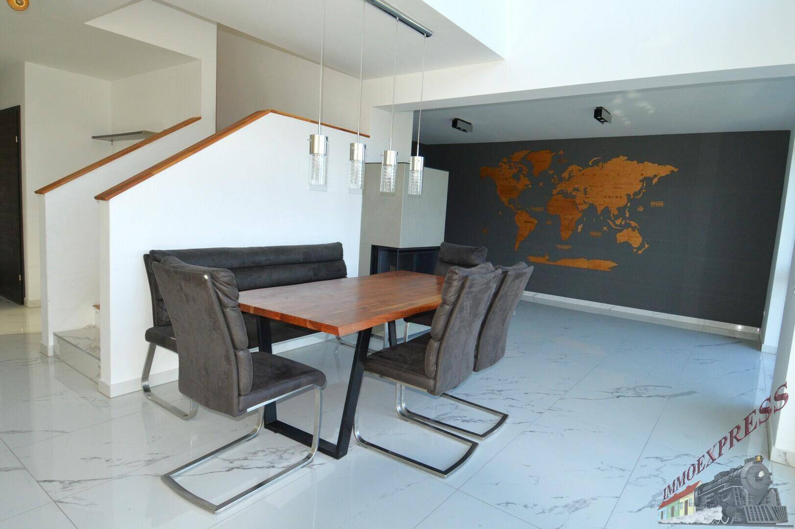 Geräumiger Essbereich mit Holztisch, modernen Stühlen und einer Weltkarte als Wanddekoration.