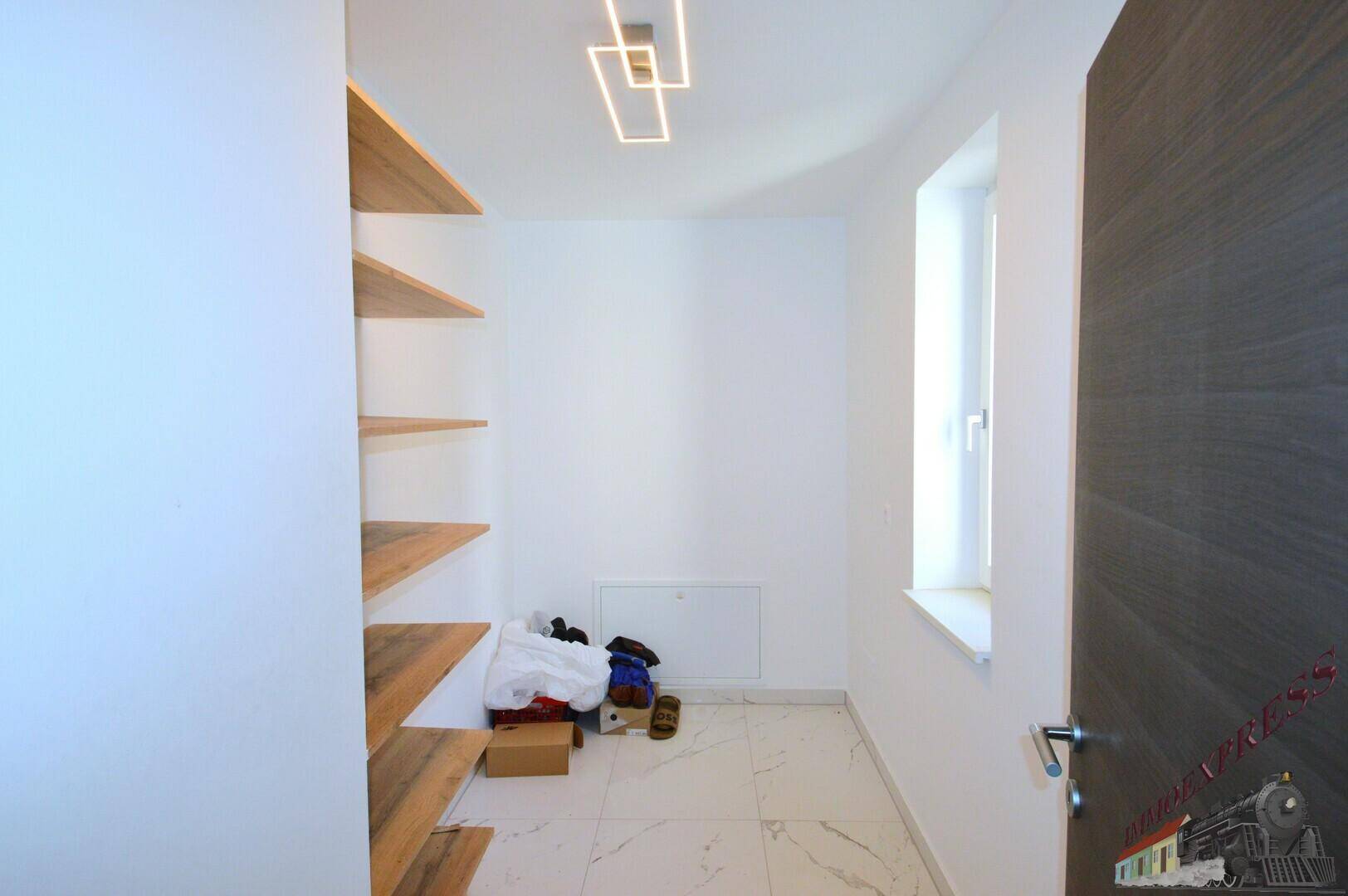 Praktischer Abstellraum mit Regalen und Fenster, ideal für zusätzlichen Stauraum im Haus.