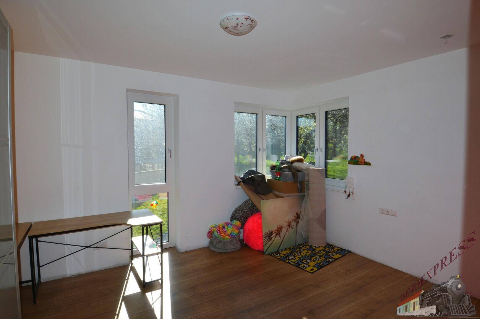 Leerer Raum mit Holzboden und mehreren Fenstern, bereit zur individuellen Gestaltung.
