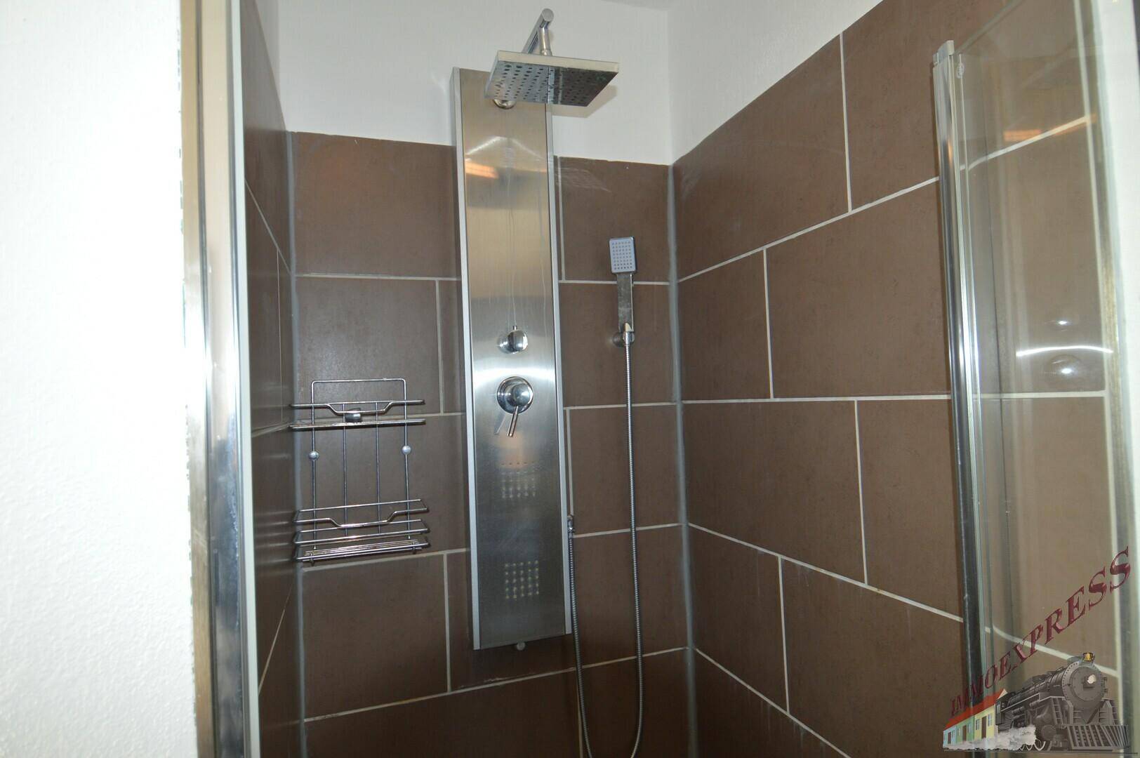 Geräumige Dusche mit modernen braunen Fliesen und einer Regendusche für entspannende Momente.