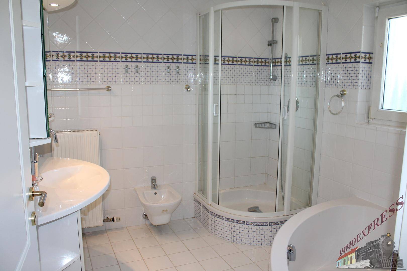 Großes Badezimmer mit Duschkabine, Badewanne, Bidet und Waschbecken.