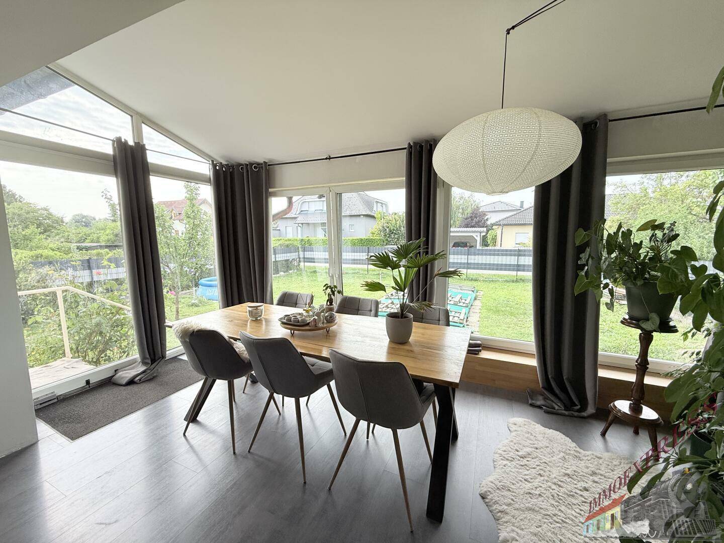 Lichtdurchfluteter Essbereich mit Panoramablick auf den Garten durch große Fenster.