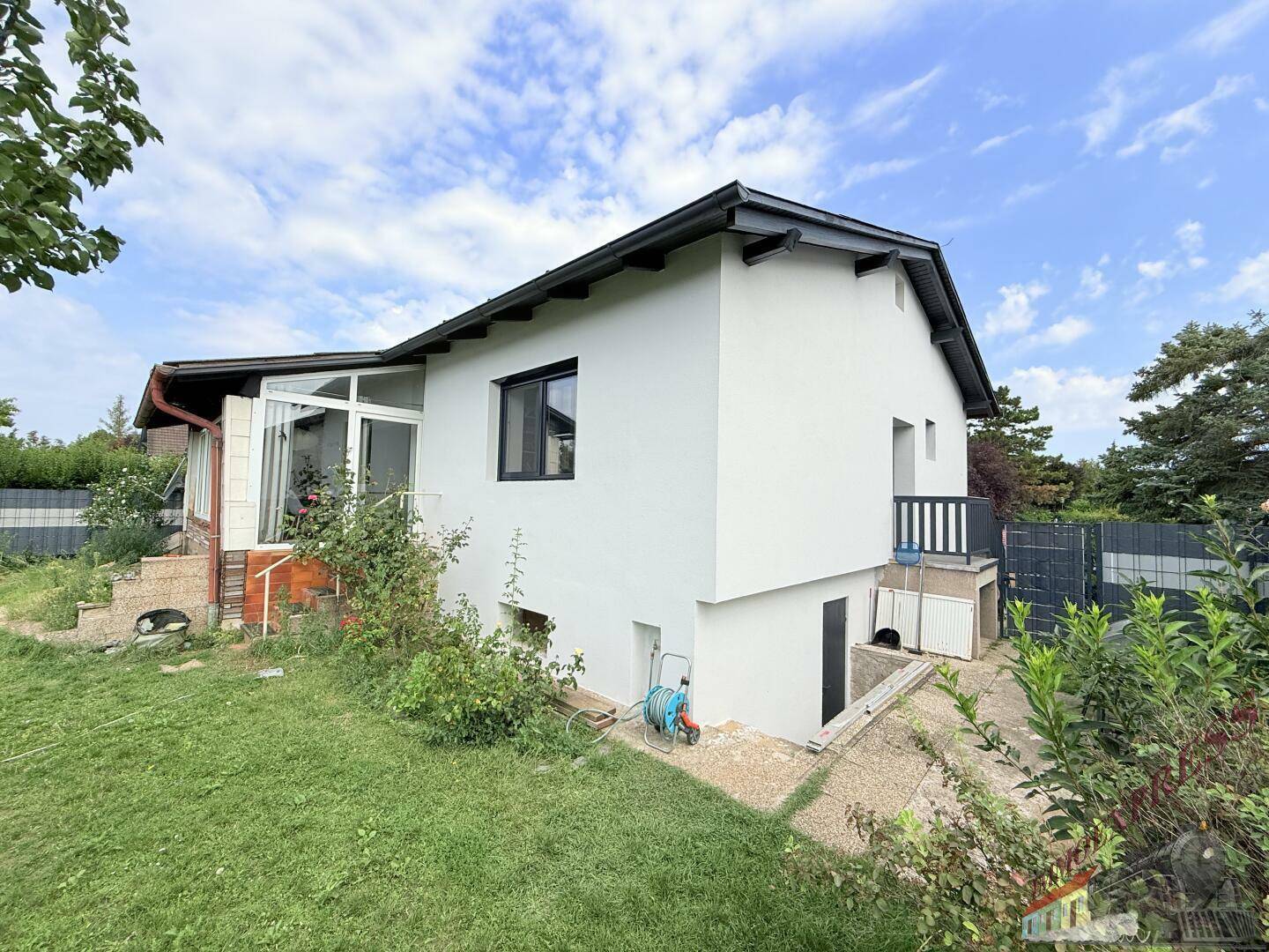 Seitenansicht des Hauses mit Anbau eines Wintergartens und Zugang zum Untergeschoss.
