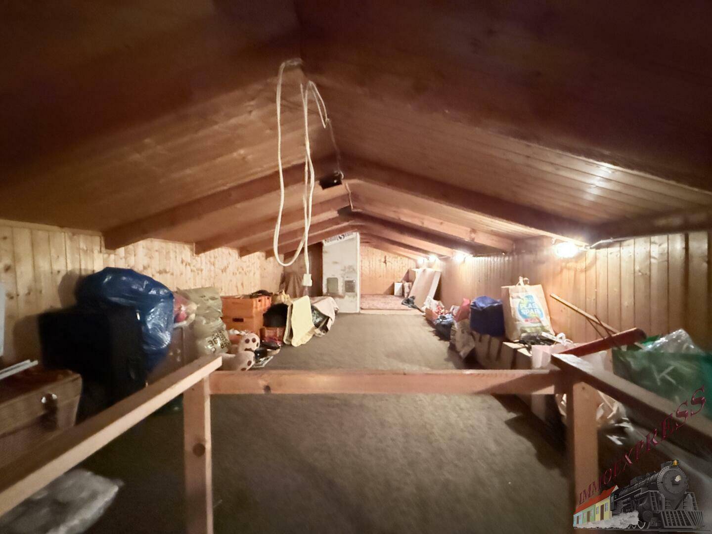 Geräumiger Dachboden als Abstellraum genutzt, mit sichtbaren Holzbalken und Schrägen.