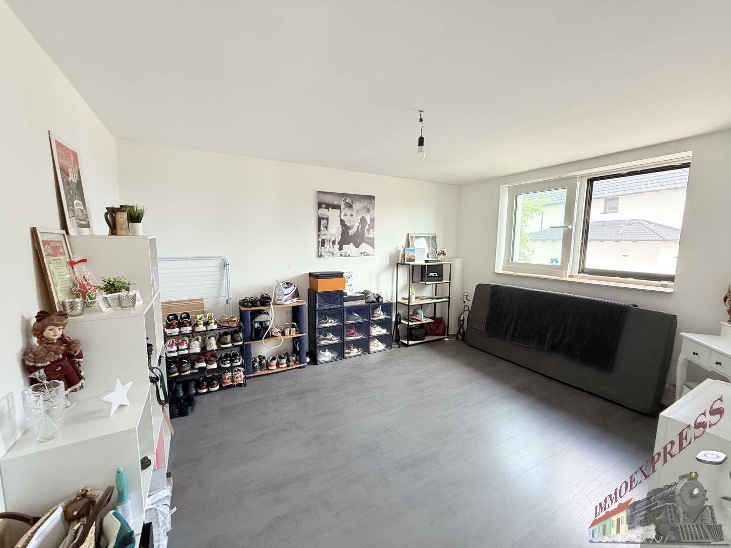 Geräumiger Raum mit Regalen für Schuhe und einem Sofa, vielseitig nutzbar.