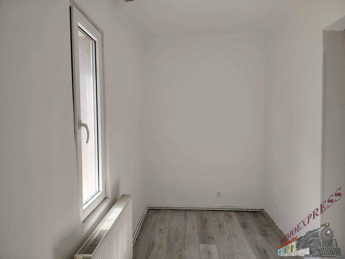 Kleines, helles Zimmer mit Laminatboden, Fenster und Heizkörper, vielseitig nutzbar.
