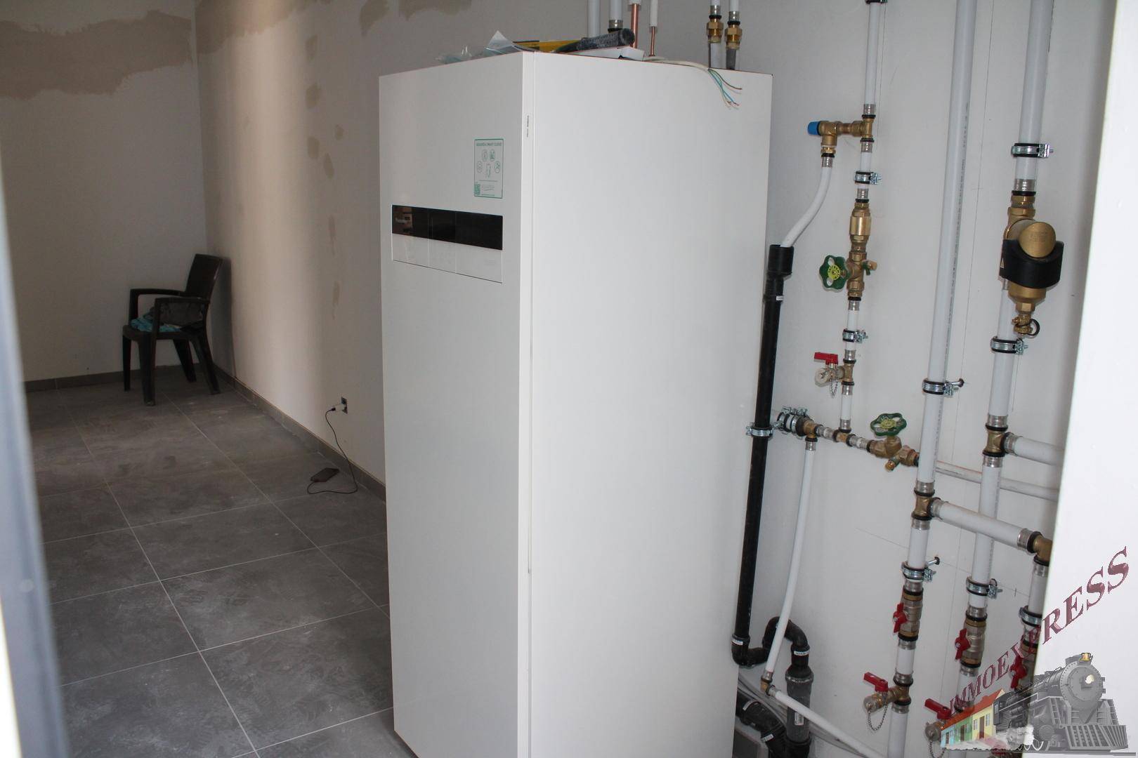 Technikraum mit moderner Heizungsanlage und sichtbaren Rohrleitungen.
