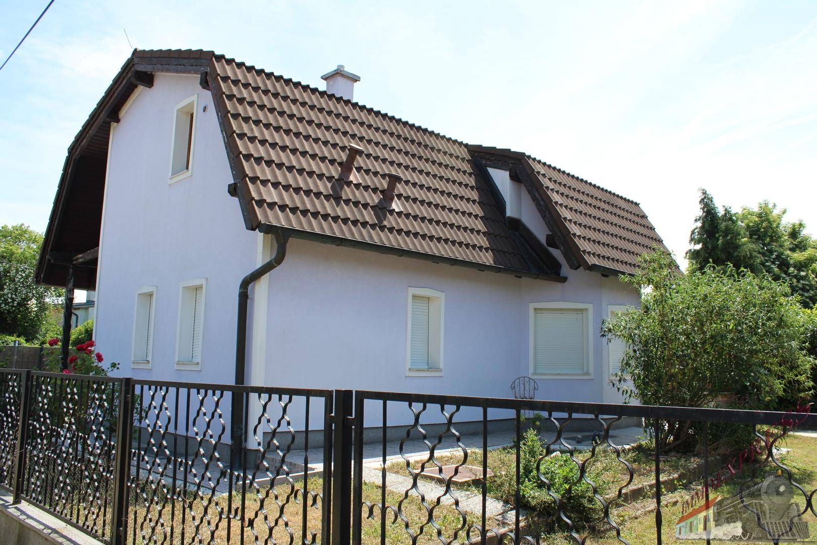 Ansicht des Hauses von der Straße mit dekorativem Zaun und gepflegter Fassade.