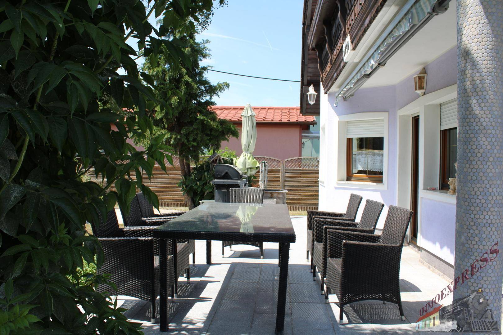 Detailansicht des Essbereichs auf der Terrasse, umgeben von grünen Pflanzen für Privatsphäre.