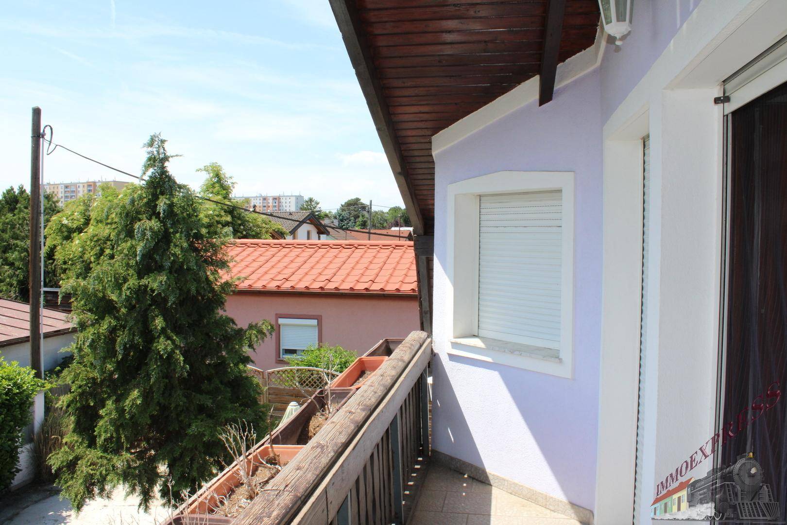 Balkon mit Holzbalkon und Blick auf die umliegenden Häuser und die Nachbarschaft.