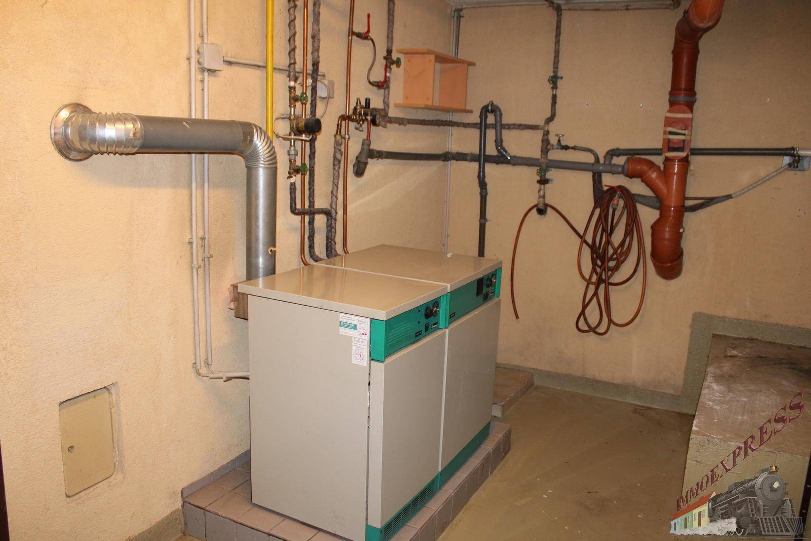 Heizungsraum im Untergeschoss mit zentraler Heizungsanlage und sichtbaren Rohren.