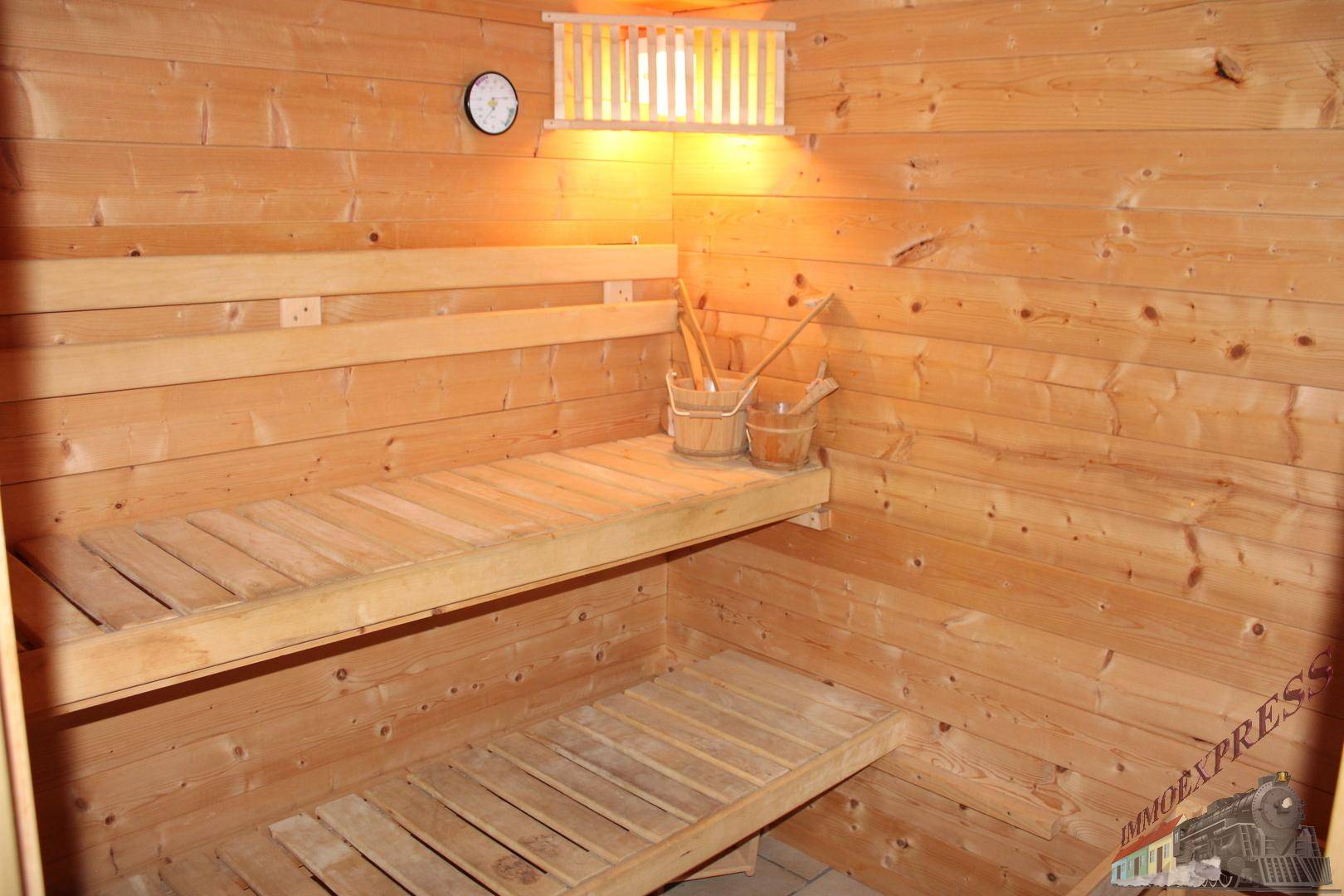 Gemütliche Sauna mit Holzverkleidung und Sitzbänken, bereit für entspannende Momente.