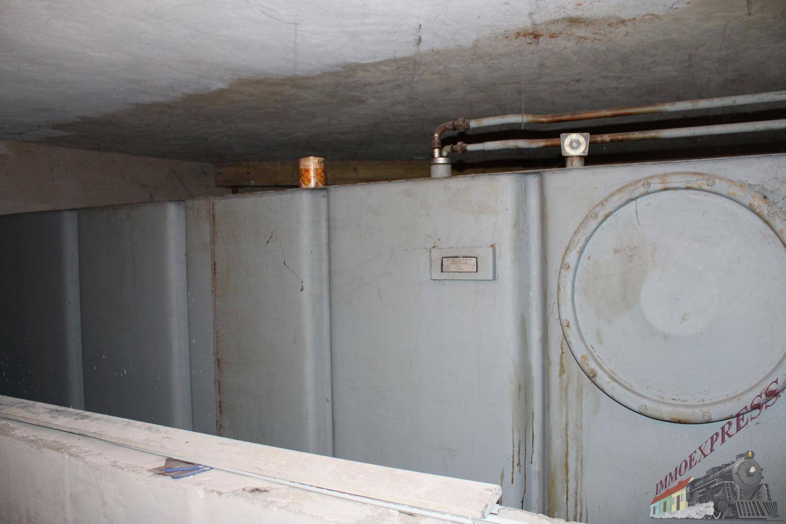 Großer Tank im Keller, wahrscheinlich für Heizöl, mit sichtbaren Leitungen.