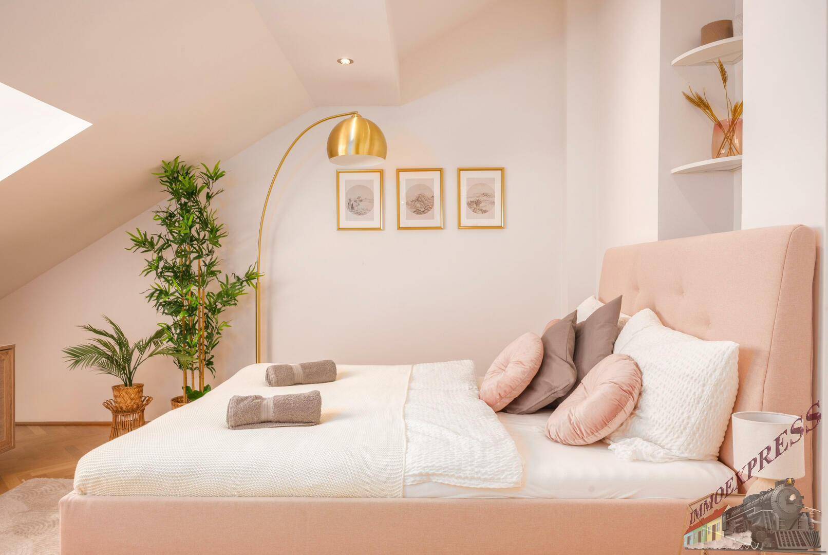 Helles Schlafzimmer mit Dachschrägen, Dachfenster und modernem Bett in Pastellfarben.