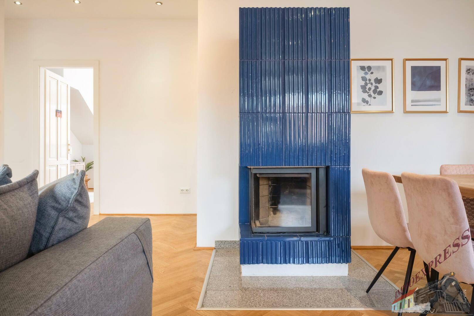 Moderner Kamin in leuchtendem Blau als Blickfang im offenen Wohn-Essbereich.