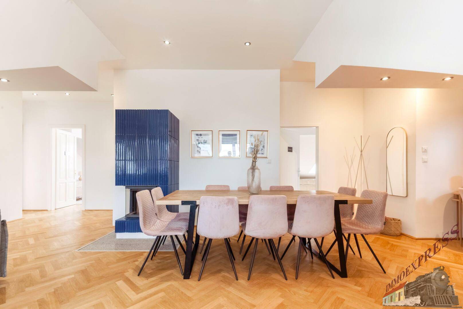 Geräumiger Essbereich mit großem Holztisch, modernen Stühlen und blauem Kamin.