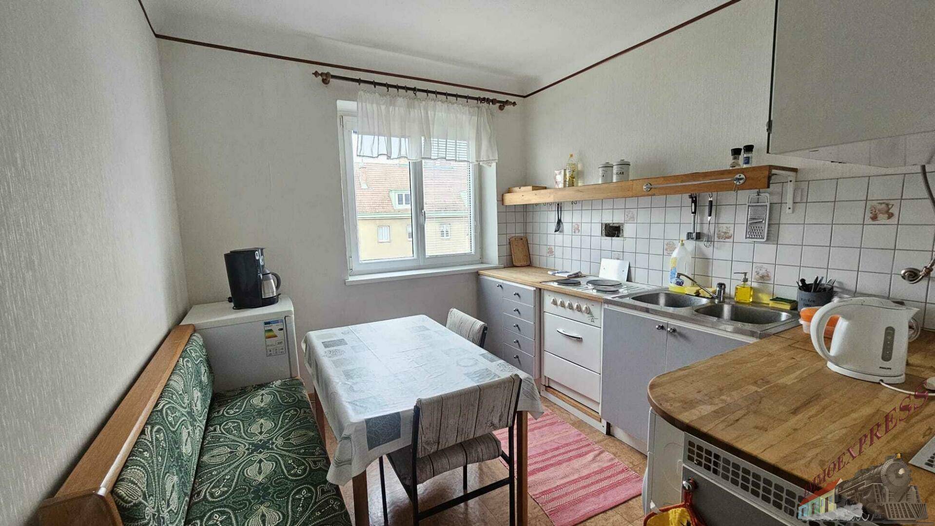 Funktionale Küche mit Essbereich, Holztheke und Fenster mit Blick nach draußen.