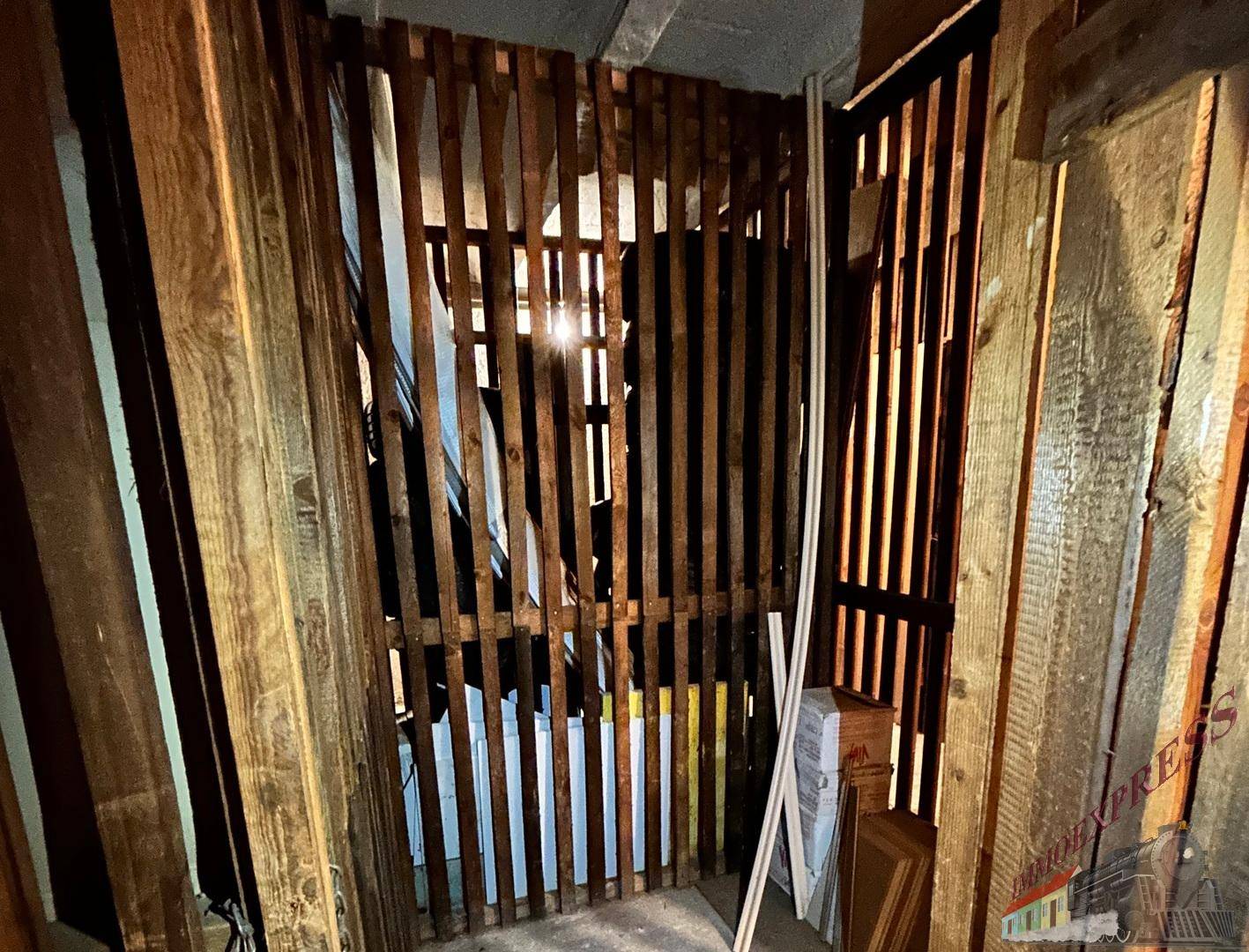 Abstellraum oder Kellerabteil mit Holzlattenwänden und Stauraum.