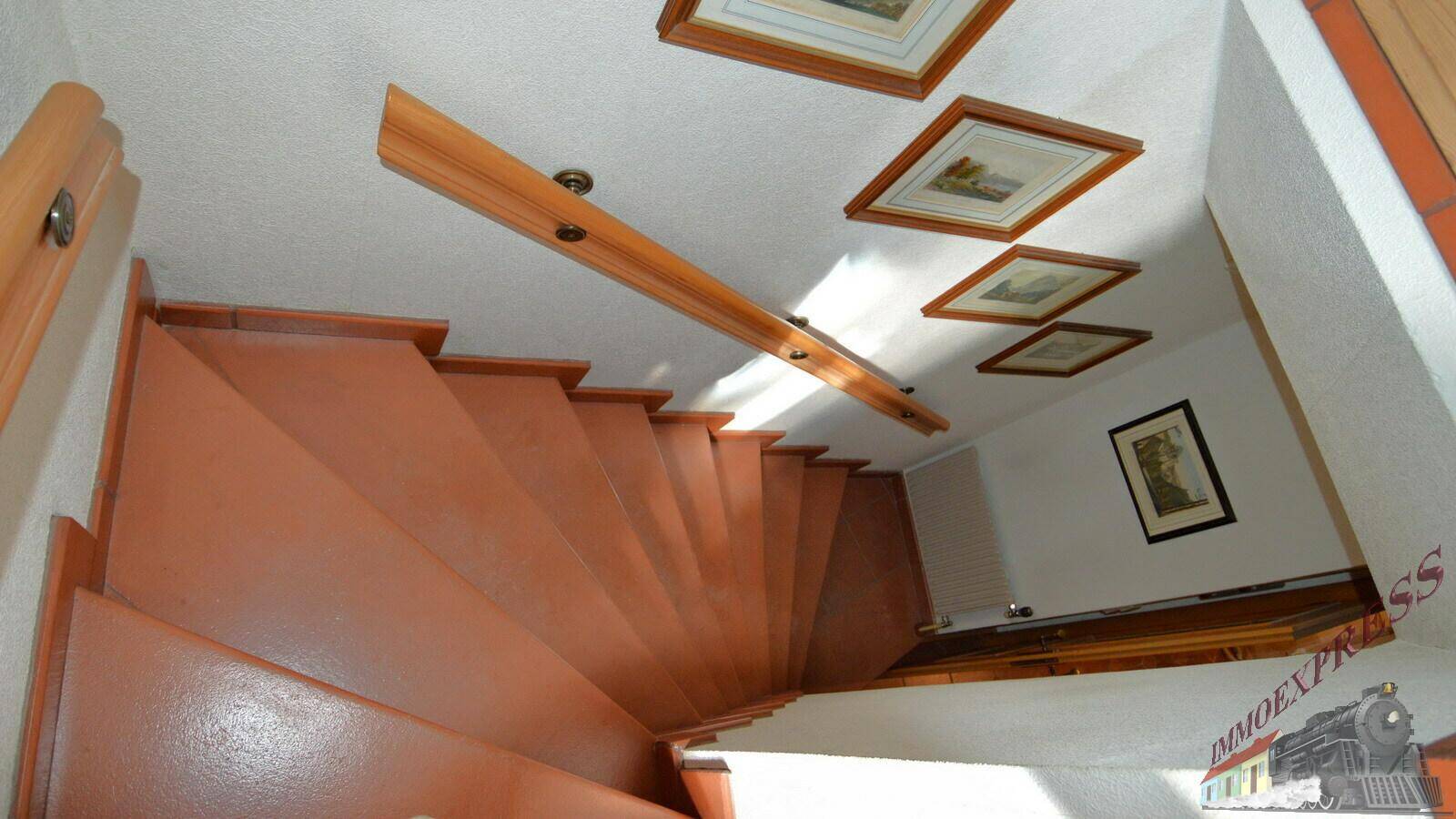 Holztreppe mit einfacher Gestaltung, die die verschiedenen Ebenen des Hauses miteinander verbindet.