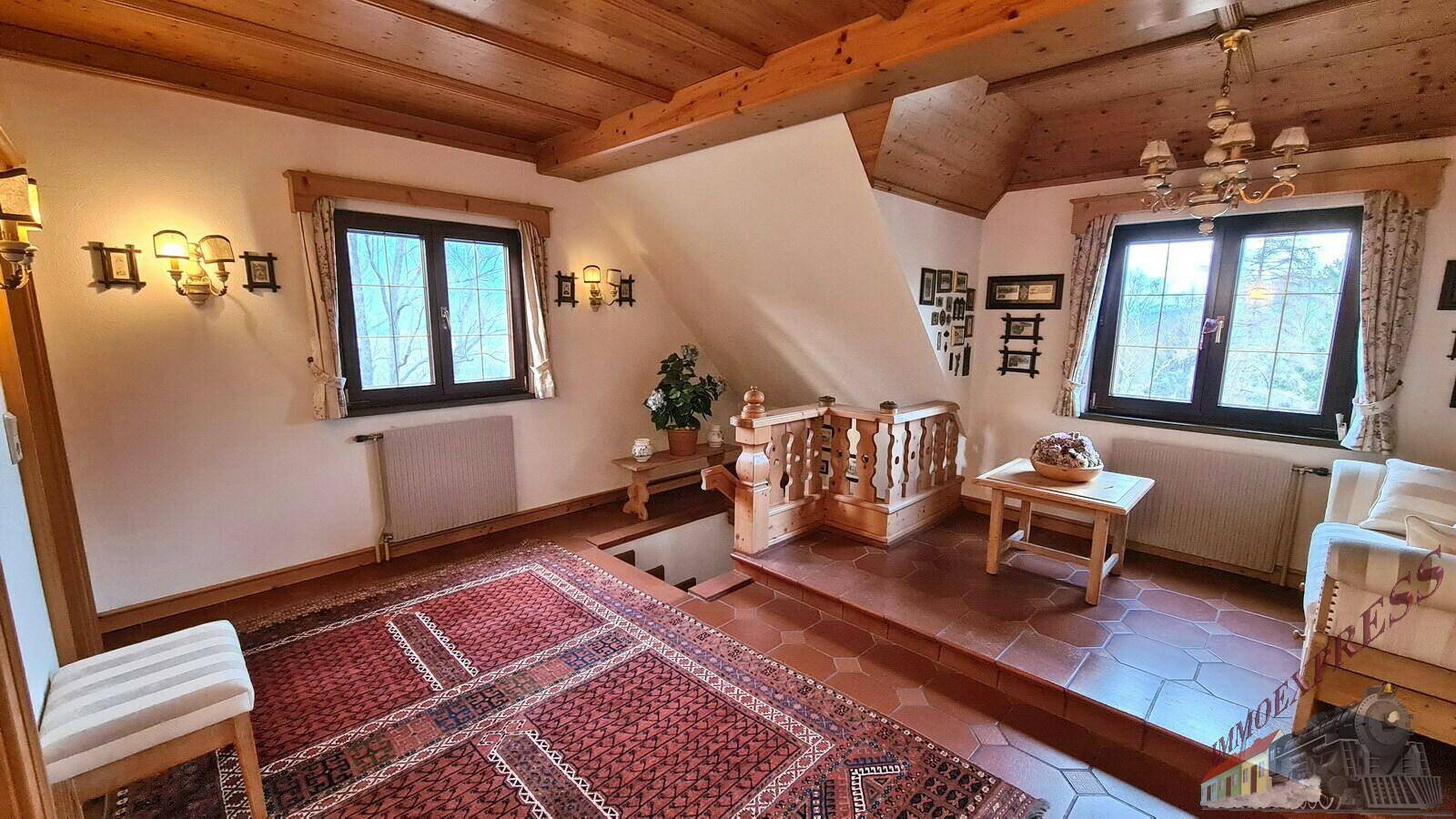 Geräumiger Flur im Dachgeschoss mit Holzbalken und Fliesenboden, der zu den Schlafzimmern führt.
