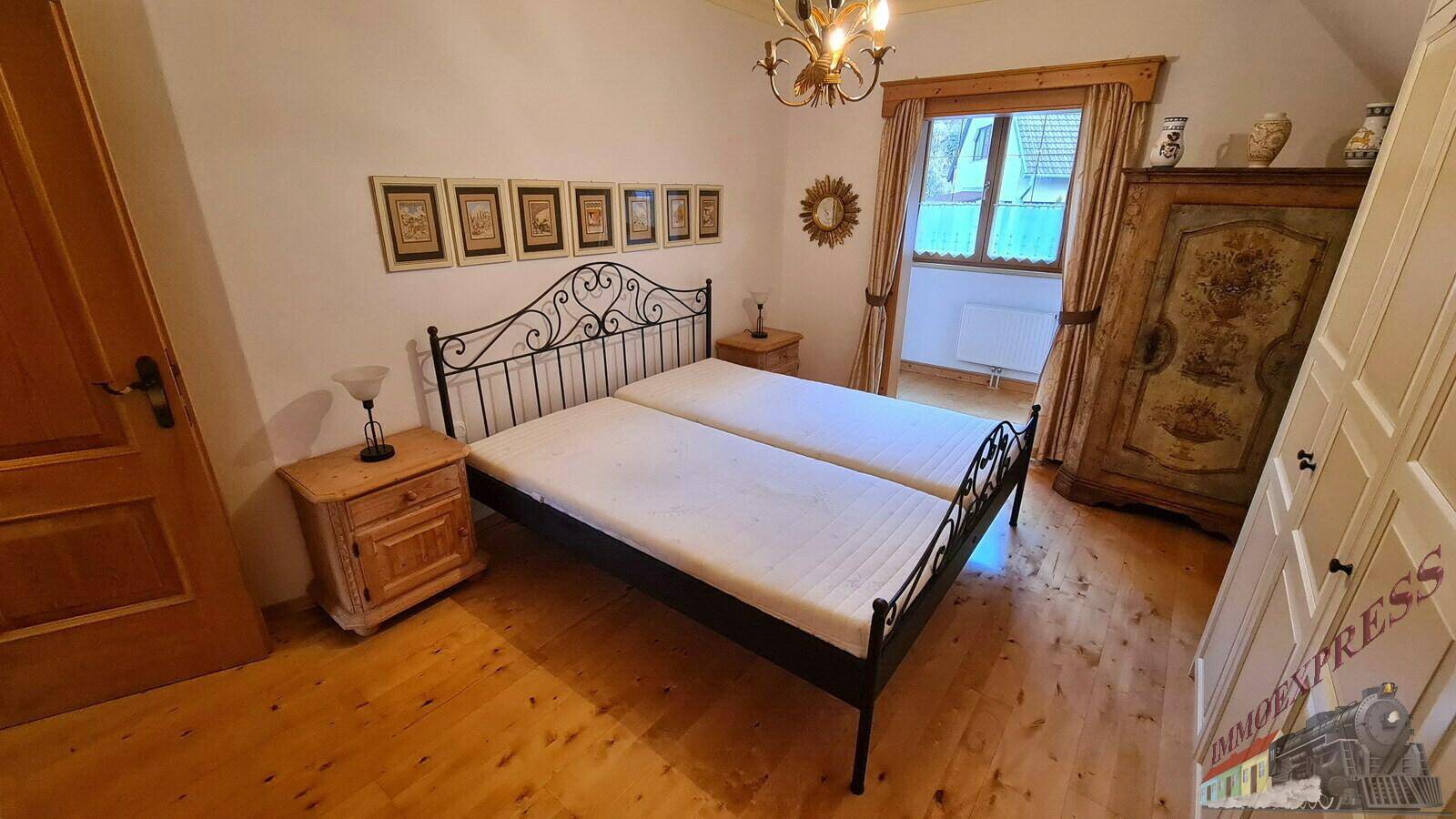 Schlafzimmer mit Holzboden und traditionellen Möbeln, bietet eine gemütliche Atmosphäre.