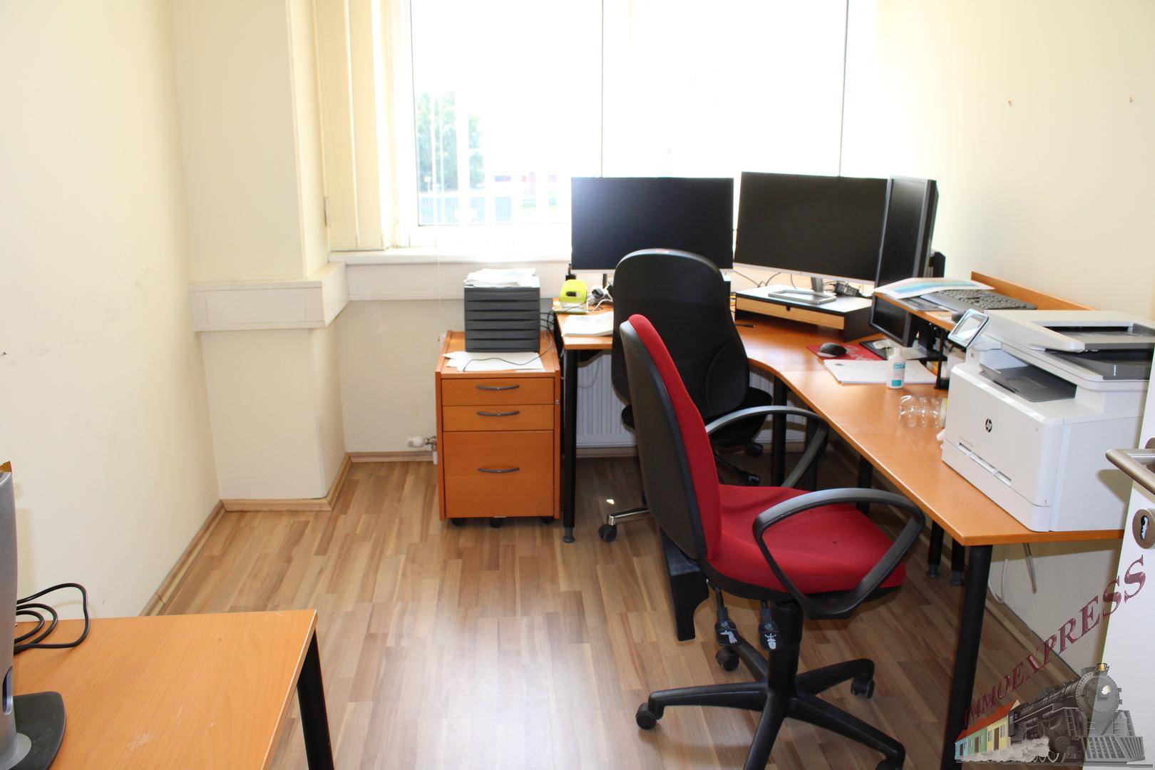 Kleines, eingerichtetes Büro mit zwei Arbeitsplätzen, Computern und Drucker, mit Laminatboden.