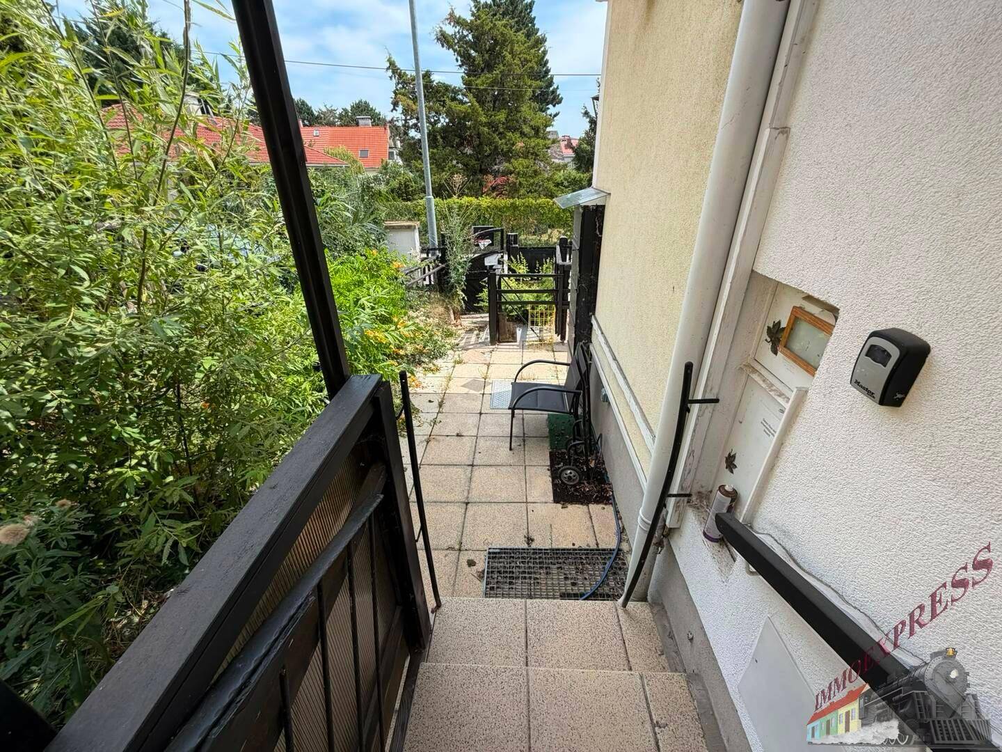 Außentreppe führt entlang der Hauswand zu einem unteren Bereich des Grundstücks.