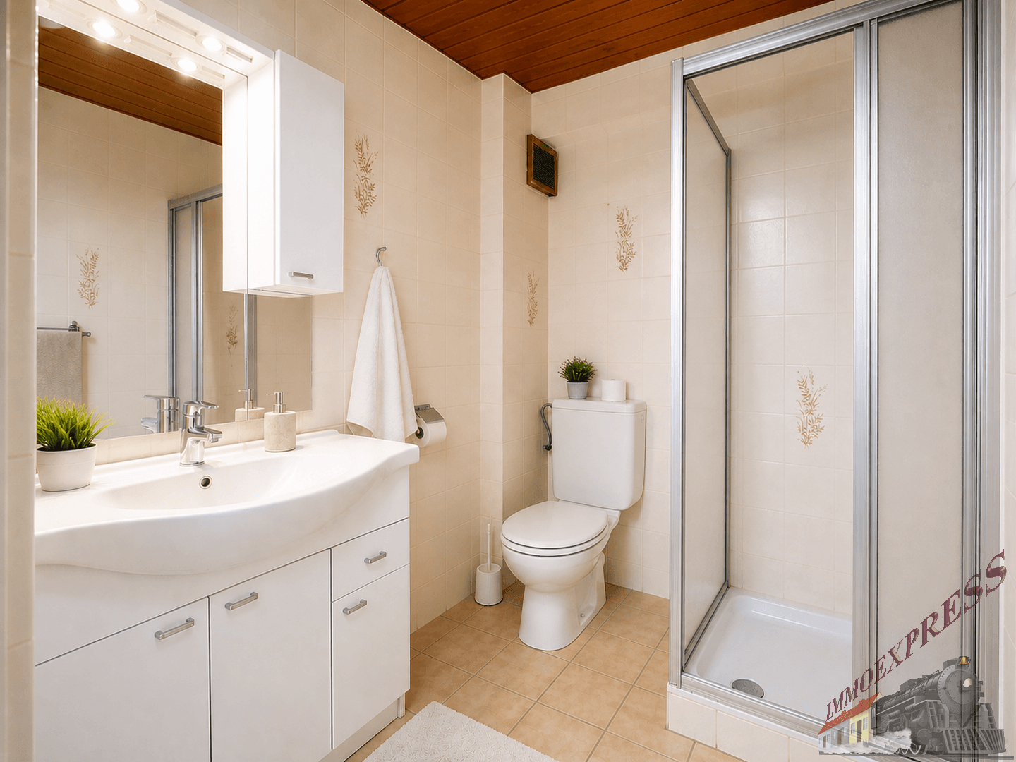 Funktionales Badezimmer mit Dusche, WC, Waschbecken und beigen Fliesen sowie Holzdecke.
